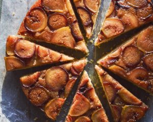 Closeup of roasted fig cornmeal spoon cake drizzled with basil honey syrup in warm golden light